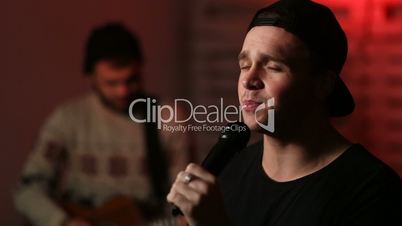 Young passionate male singer performing on stage