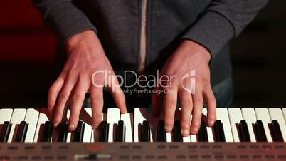 Man hands playing electronic keyboard on stage