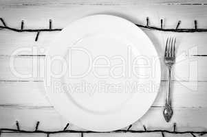 White empty plate with a fork