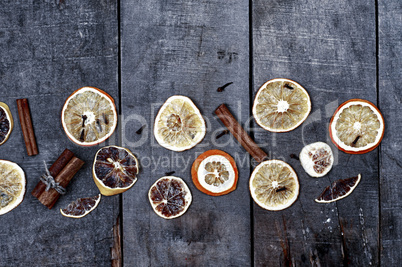 Slices of orange and lemon on a gray wooden surface