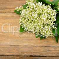 Bouquet lily of the valley on wooden table.