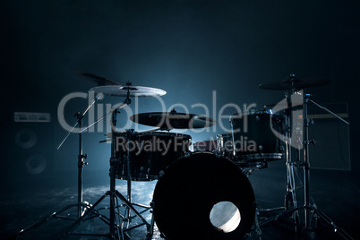 Modern drum set shot in smoky dark studio