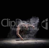 Graceful woman dancing in cloud of white dust