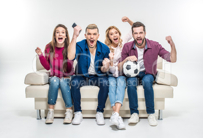 Friends sitting on couch with soccer ball