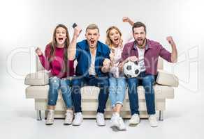Friends sitting on couch with soccer ball