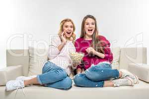 Friends eating popcorn on couch