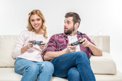 Smiling couple playing with joysticks