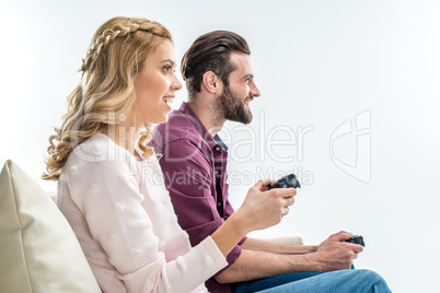 Smiling couple playing with joysticks