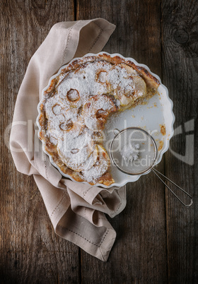Apple pie and a napkin on wooden table.