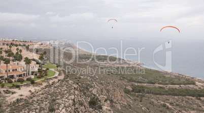 Paragliders flying by the seaside
