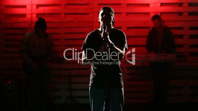 Emotional singer singing on illuminated stage