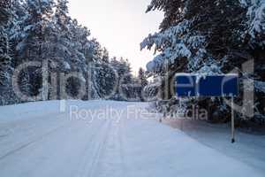 Winter road landscape with traffic sign