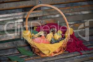 Woven basket of autumn gourds on a garden bench