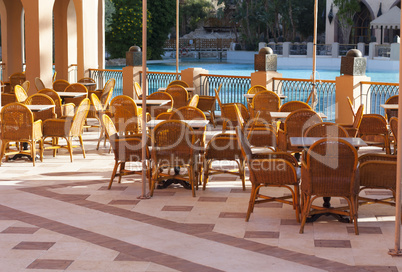 Wooden tables in a outdoor restaurant photo near water pool