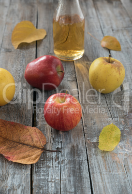 Apple cider in  bottle,  and fresh apples on wooden background.A