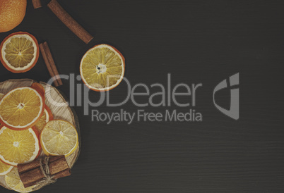 Black wood background with slices of orange and lemon