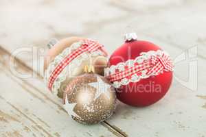 Three Christmas baubles on rustic wood