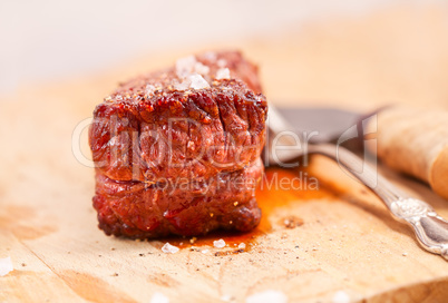 Grilled beef steak on wooden table.