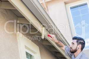 Professional Painter Using Small Roller to Paint House Fascia