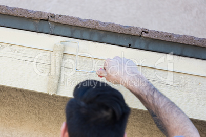 Professional Painter Using Small Roller to Paint House Facia