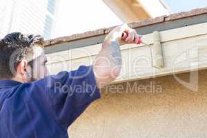 Professional Painter Using Small Roller to Paint House Fascia