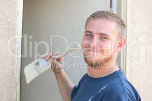Young Caucasian Man Smiling As He Is Painting House