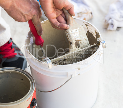 Professional Painter Loading Paint Onto Brush From Bucket