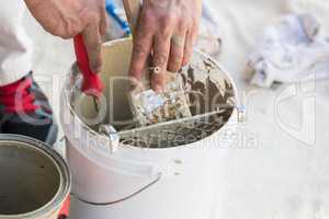 Professional Painter Loading Paint Onto Brush From Bucket