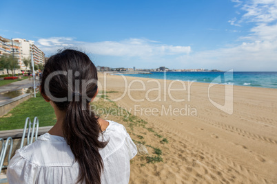 Girl on the empty beach in Spain at autumntime