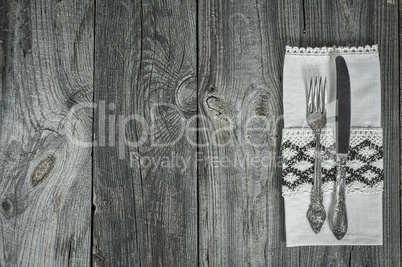 Cutlery knife and fork on gray wooden surface