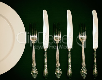 Half empty white plates, vintage knife and fork