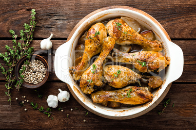 Roasted chicken legs on rustic wooden background, top view