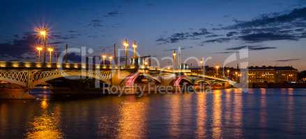 Night cityscape with river and bridge in Saint-Petersburg.