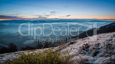 Sunrise on mountain with fog and iced grass.