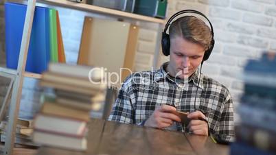 Young male student reading text message on phone