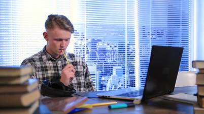 Handsome student thinking with pencil in his mouth