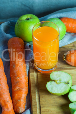 glass of carrot and apple juice on the kitchen board