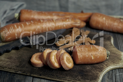 pieces of carrot and whole carrots on the chopping board