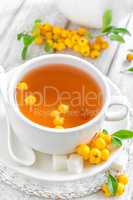 Fresh warmer herbal hawthorn tea with fresh berries in a white cup on wooden background, alternative medicine