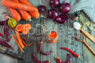 Fresh vegetables and a glass of carrot juice on an old wooden su