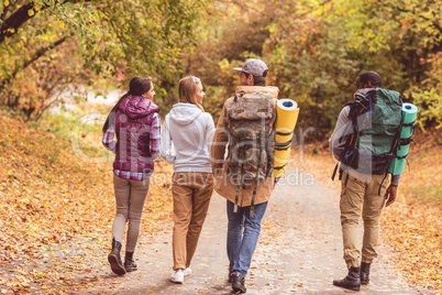 Young backpackers in autumn forest