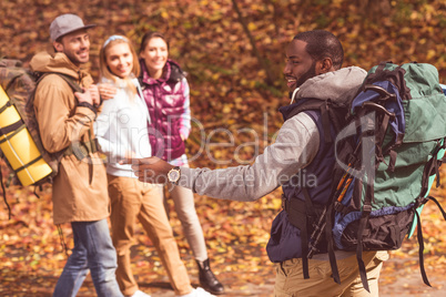 Smiling man with friends in autumn forest