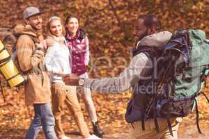 Smiling man with friends in autumn forest
