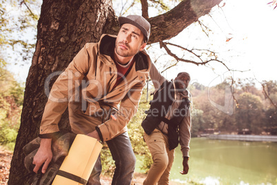 Men backpackers standing near river