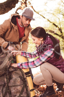 Man looking at woman packing backpack