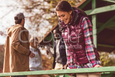 Smiling young woman leaning on railing