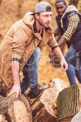 Young men near dry stumps in forest