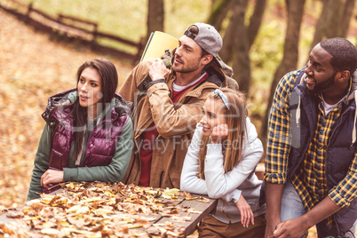 Young friends backpackers sitting at table