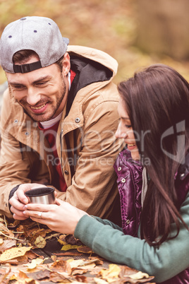 Smiling man giving cup to woman