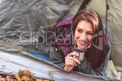 Woman in tent holding metallic cup